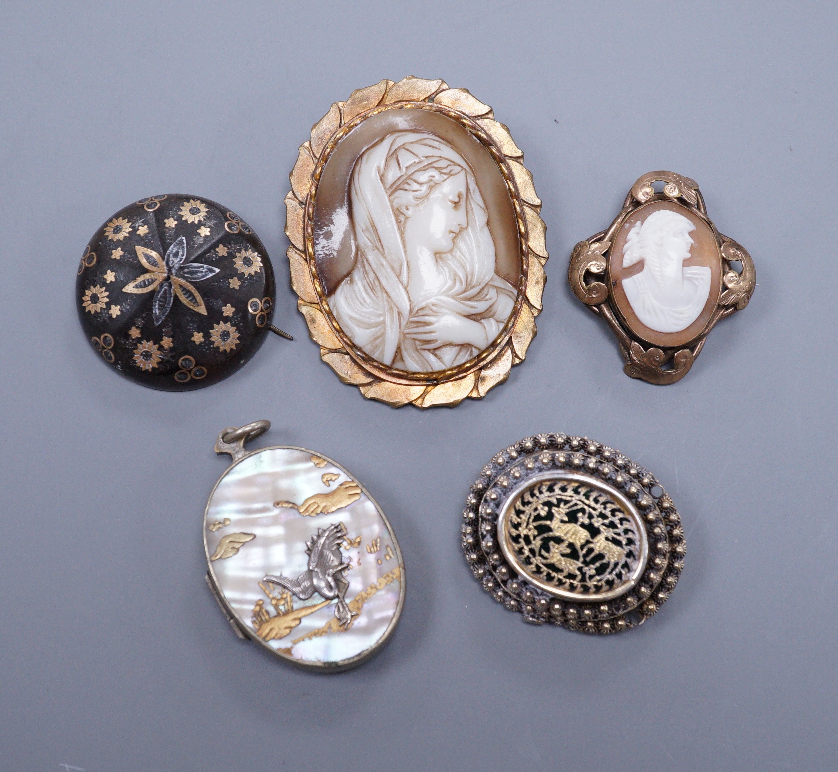 A Victorian gold pique circular brooch, 3cm (a.f.), two cameo brooches, a gilt metal brooch and a Japanese mother of pearl locket